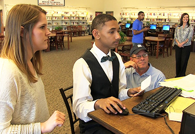 Student helps community member with taxes at John Marshall Mid-High School